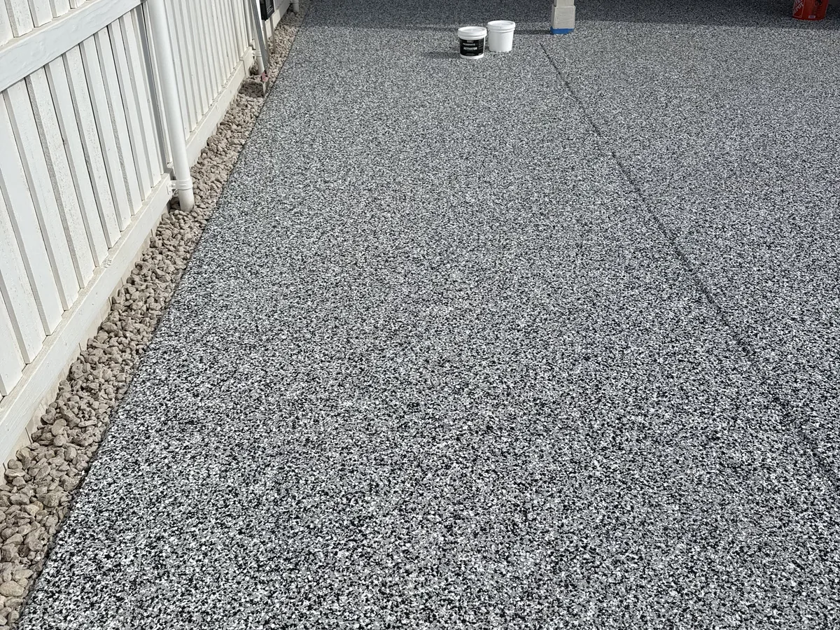 Close view of a gray and white flake floor coating on a patio
